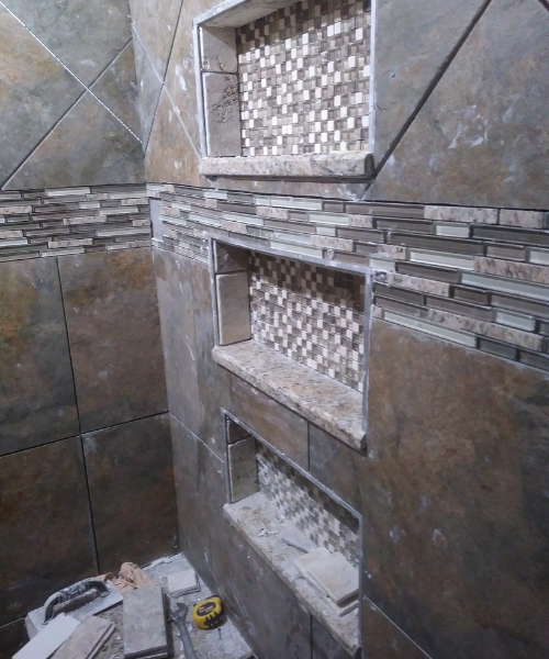 A bathroom that is being remodeled with a tile wall