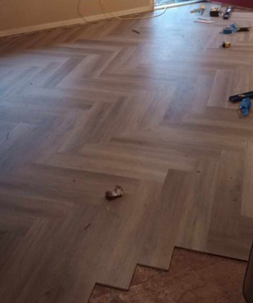 A room with hard wood flooring and tools on the floor