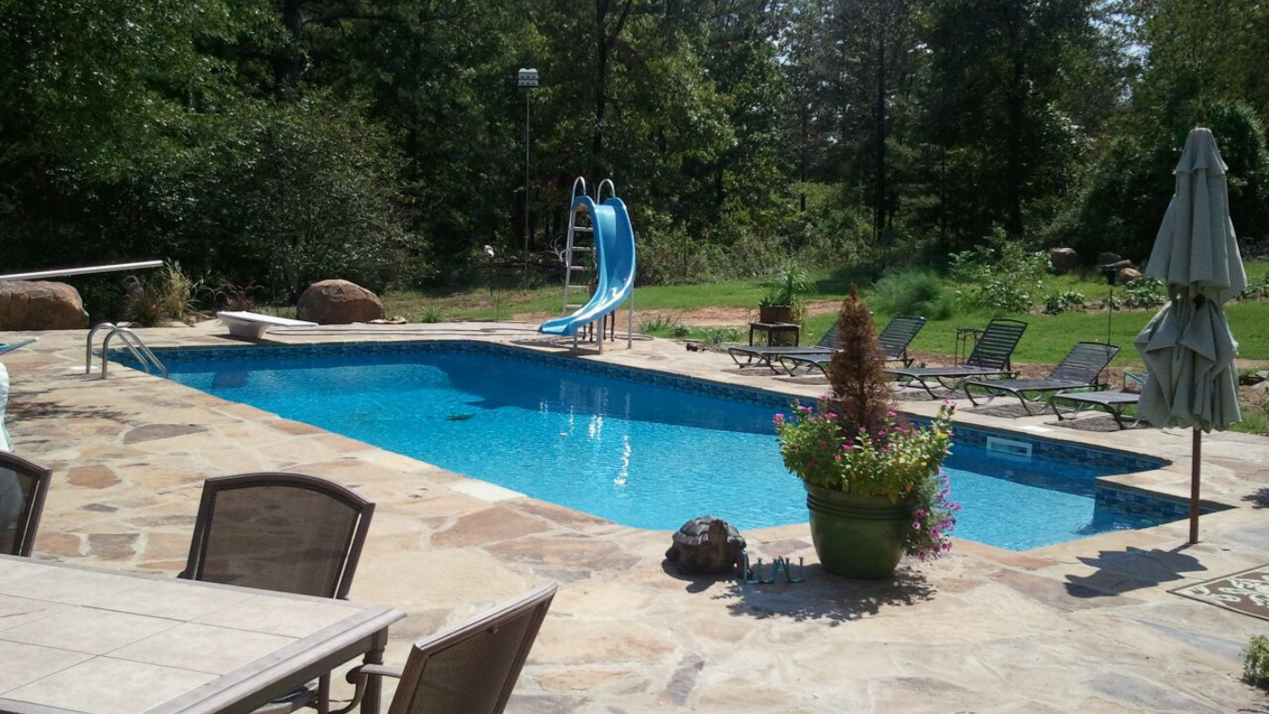 A pool with a slide in the middle of it