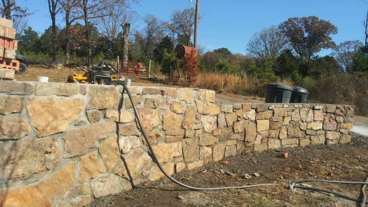 A wall made of rocks with a hose attached to it